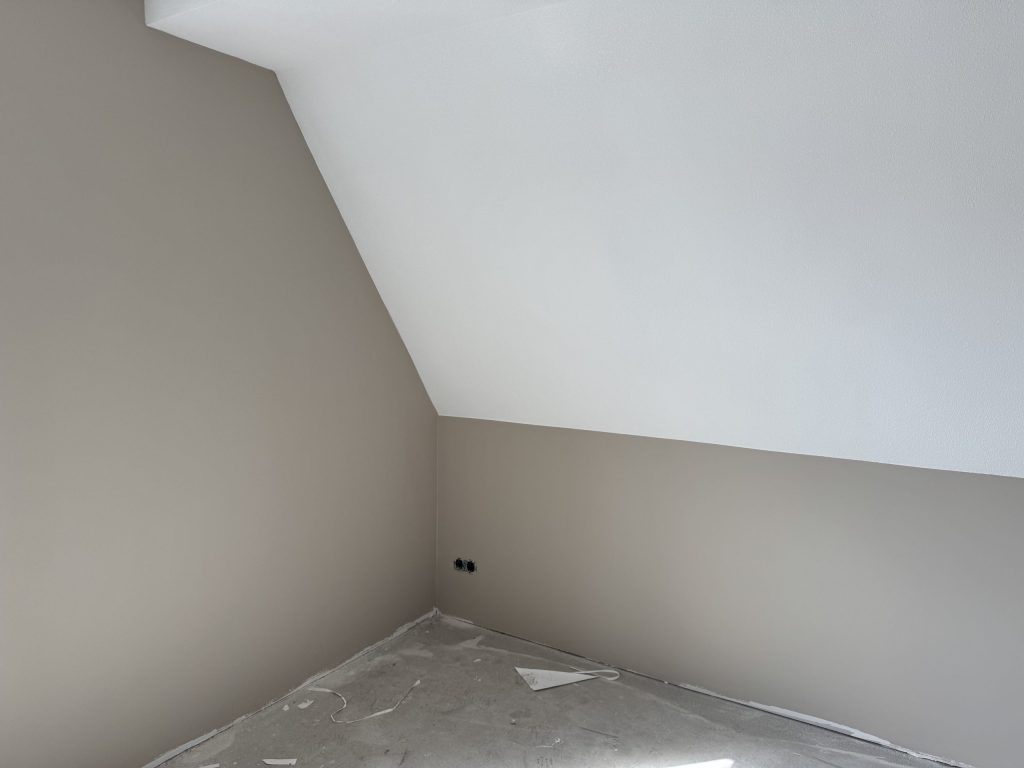 Zolderkamer met schuine wand in wit en rechte wanden in een zachte taupe tint